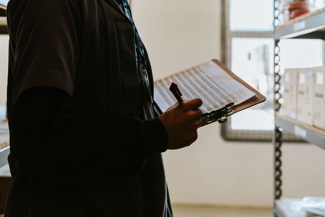 A person working through an inventory list on a clipboard